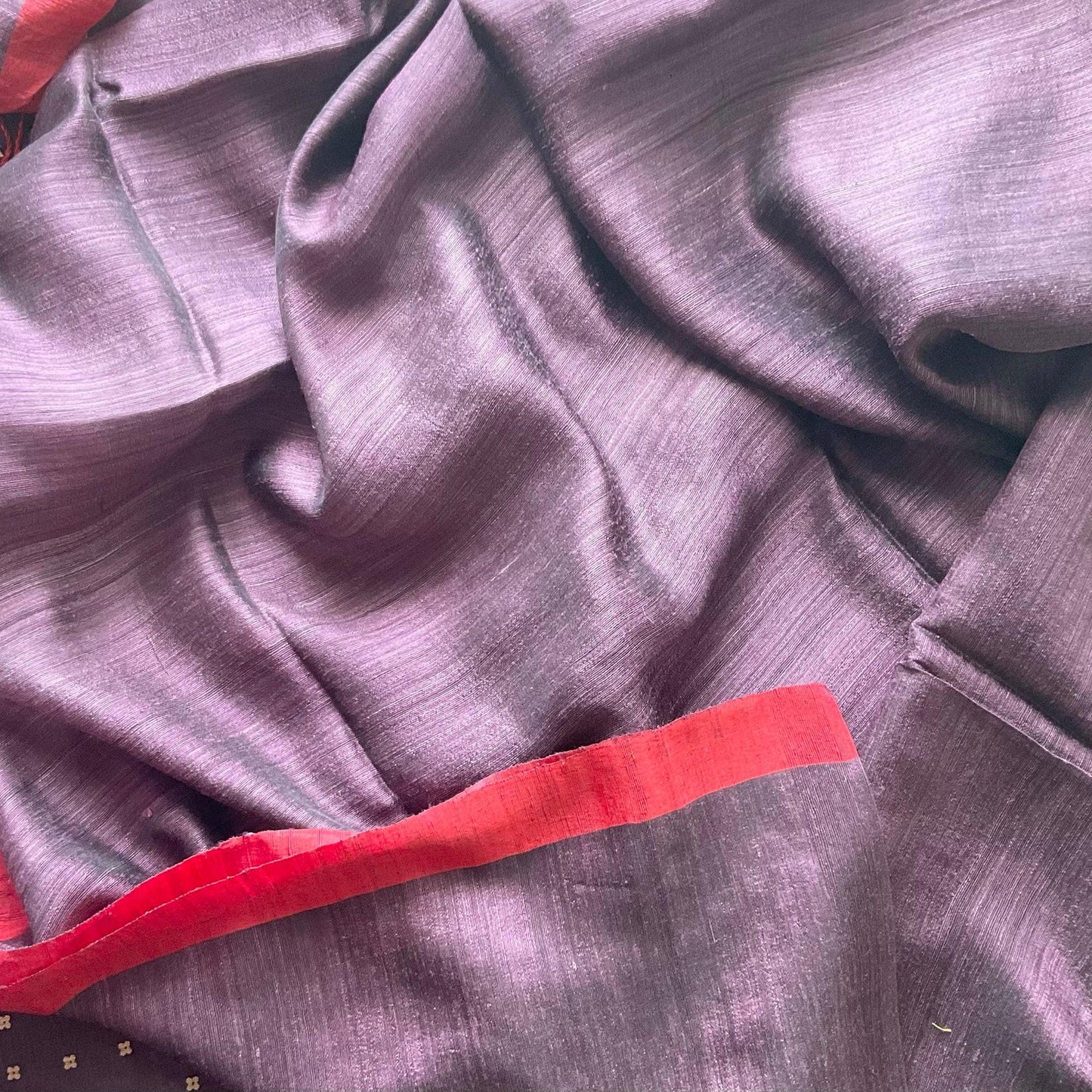 Close-up of purple fabric with a red border running blouse fabric