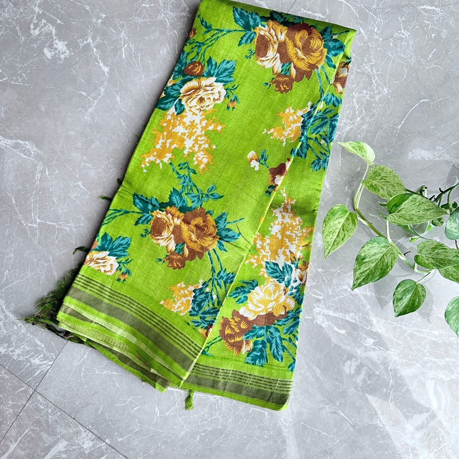Front view of modern light green floral print Tussar silk saree with thin Zari border and teal blouse, showcasing saree drape and motif scale.